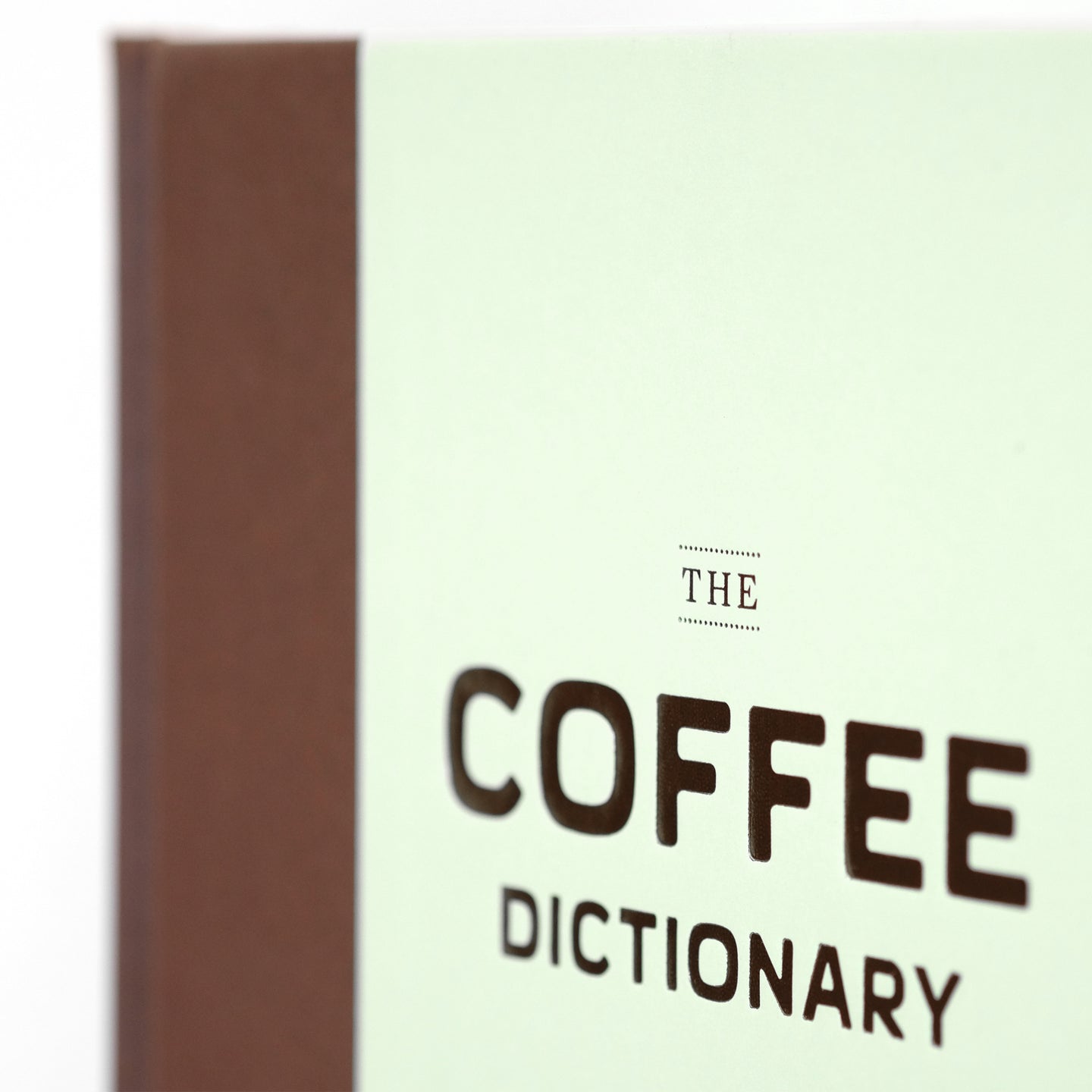 Close-up of The Coffee Dictionary accessory by Cloud Picker Coffee, showing detailed pages with coffee terminology and illustrations.