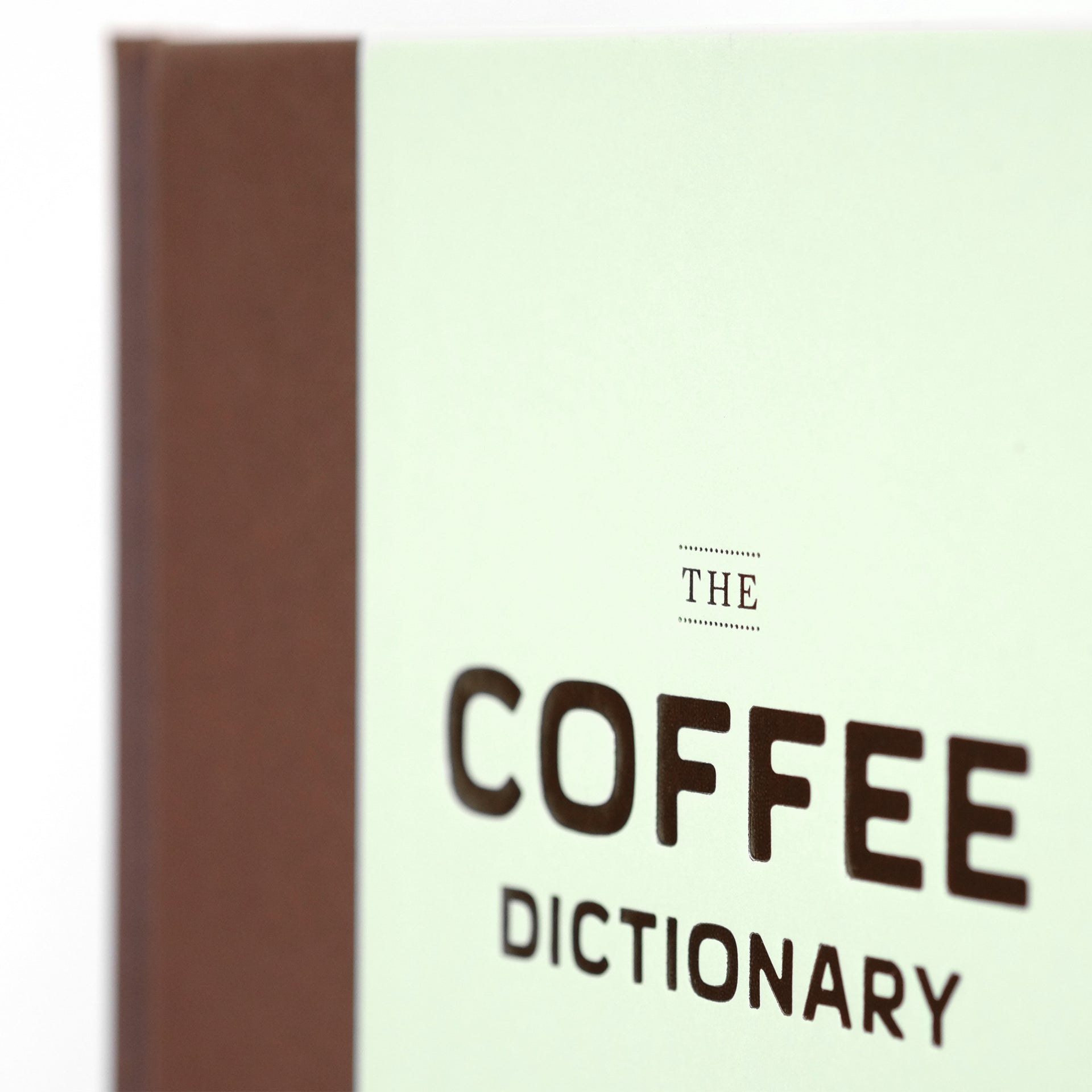 Close-up of The Coffee Dictionary accessory by Cloud Picker Coffee, showing detailed pages with coffee terminology and illustrations.