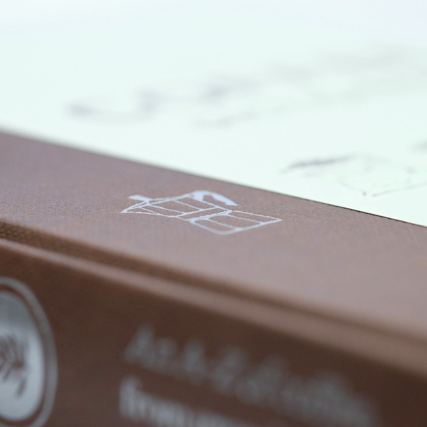Close-up of The Coffee Dictionary accessory by Cloud Picker Coffee, showing detailed pages with coffee terminology and illustrations.