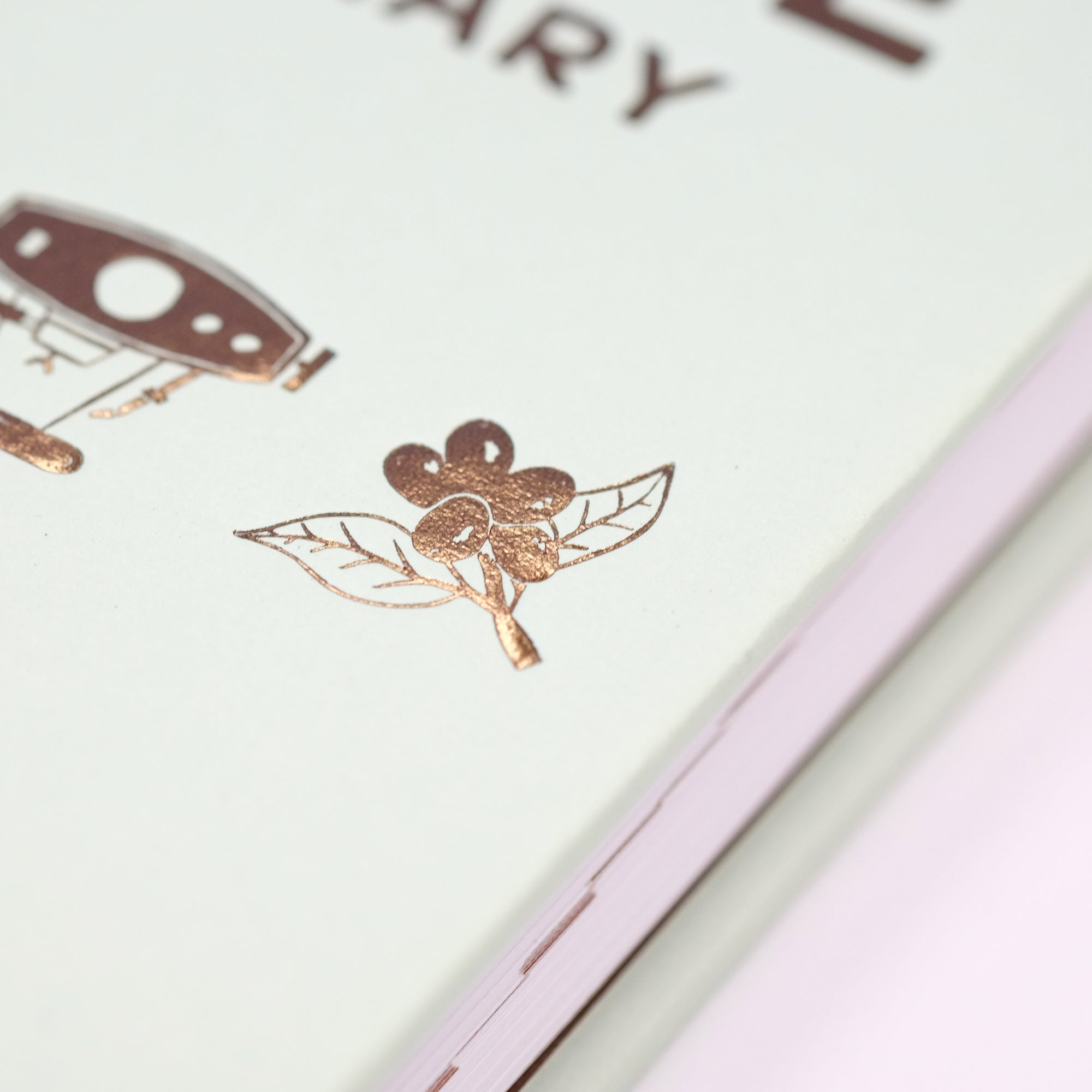 Close-up of the cover of Cloud Picker Coffee's The Coffee Dictionary accessories book, showing detailed lettering and design.