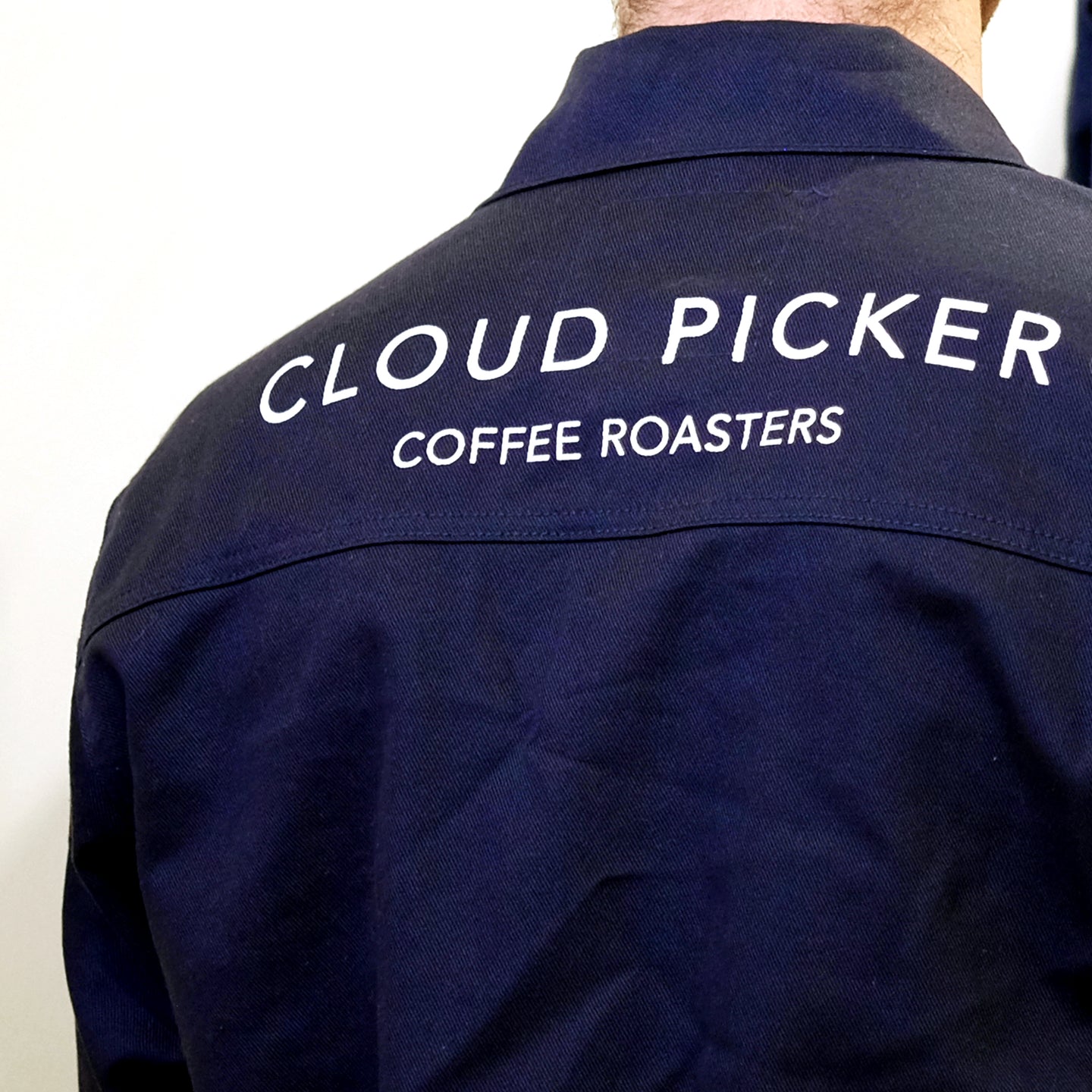 Unisex Cloud Picker Coffee roaster jacket made of durable fabric, featuring branding and adjustable collar for professional roasting comfort.