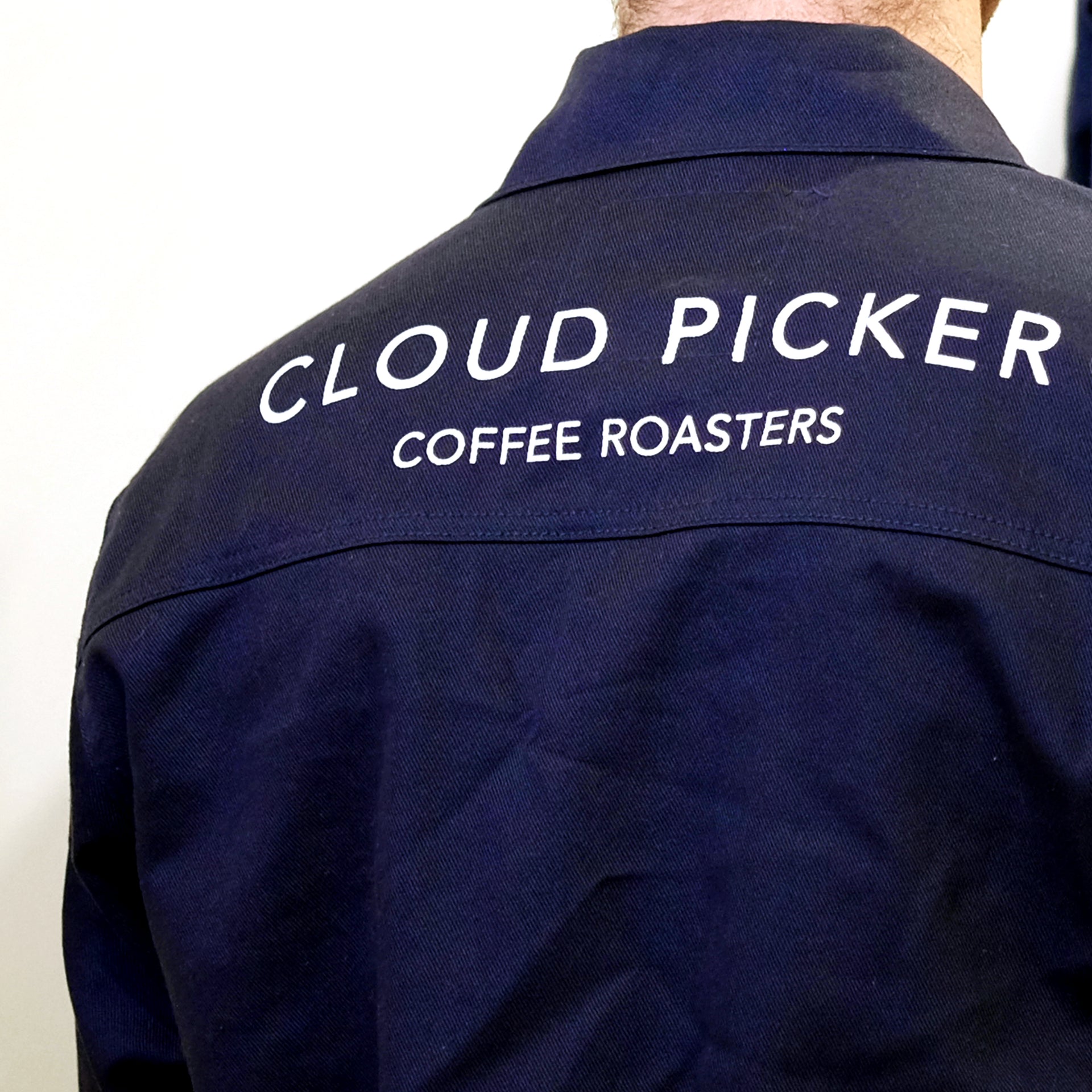 Unisex Cloud Picker Coffee roaster jacket made of durable fabric, featuring branding and adjustable collar for professional roasting comfort.